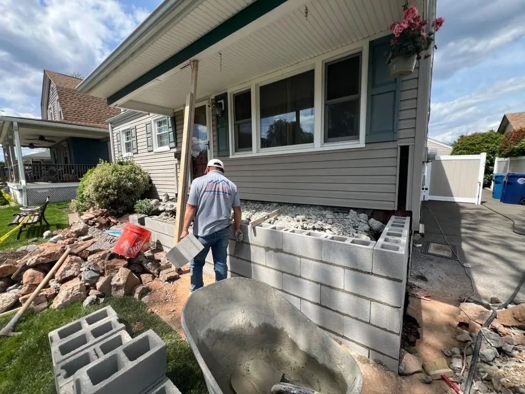 Pro One mason building a concrete block foundation for a new front porch