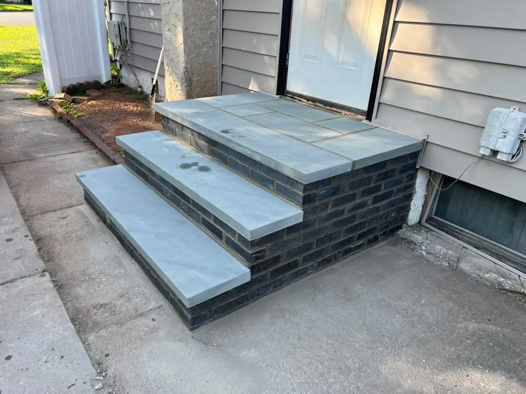 Bluestone-capped steps with dark brick risers at a side entry