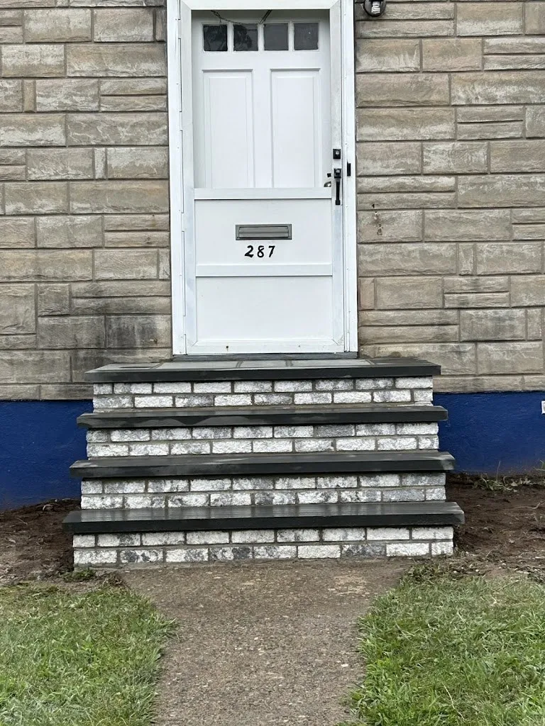 Whitewashed brick front steps with dark bluestone treads
