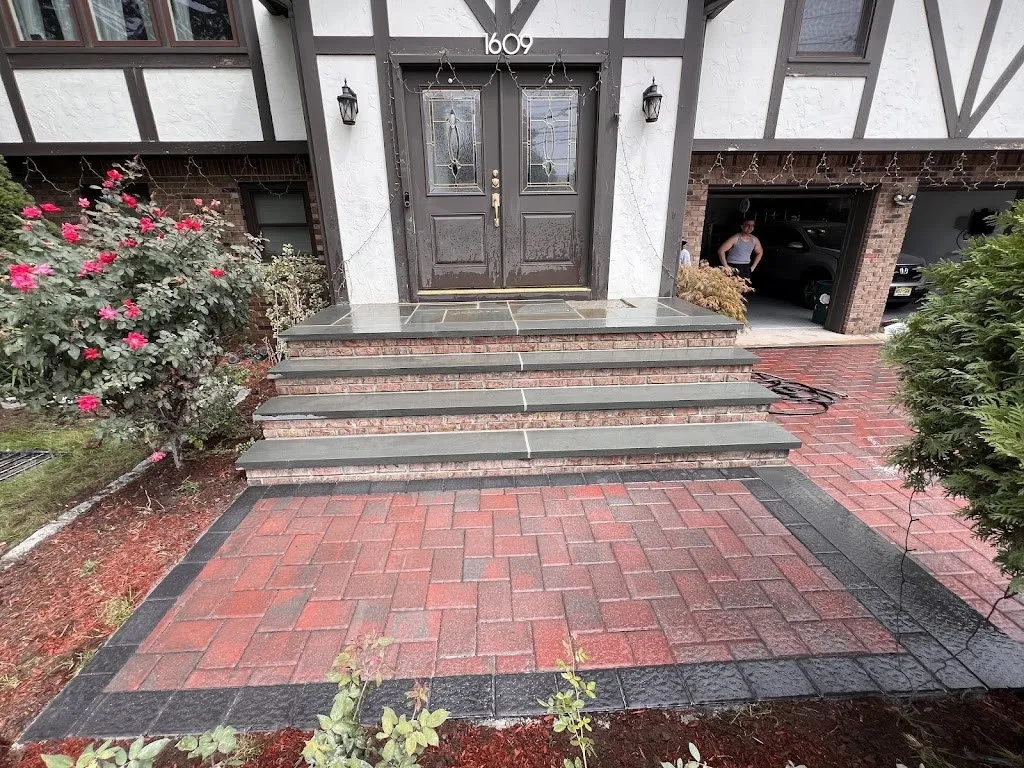 Red paver entry court with bluestone steps at a Tudor home