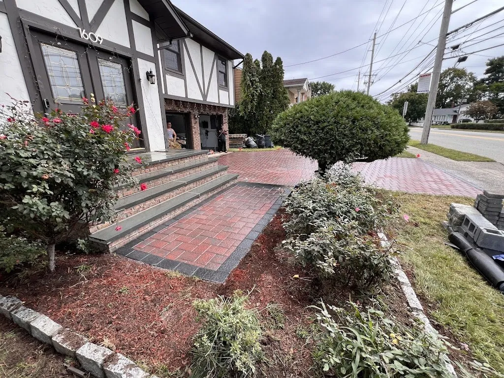 Paver entry and bluestone steps framed by roses and shrubs