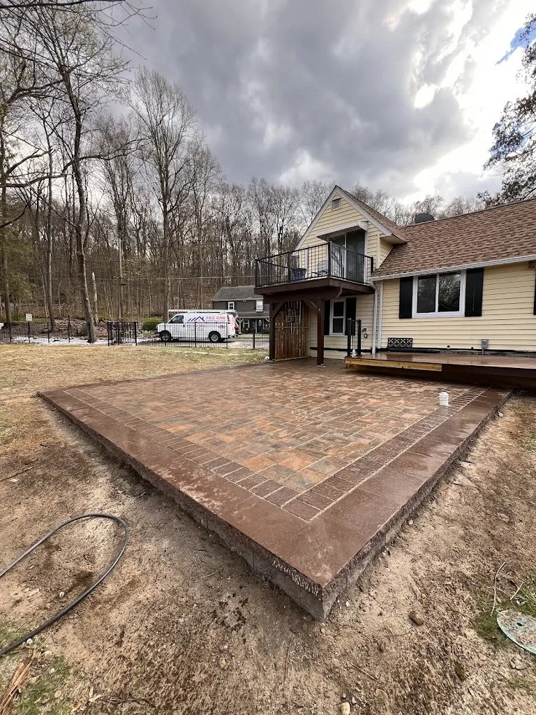 Large red-tone paver patio with soldier course border, freshly installed