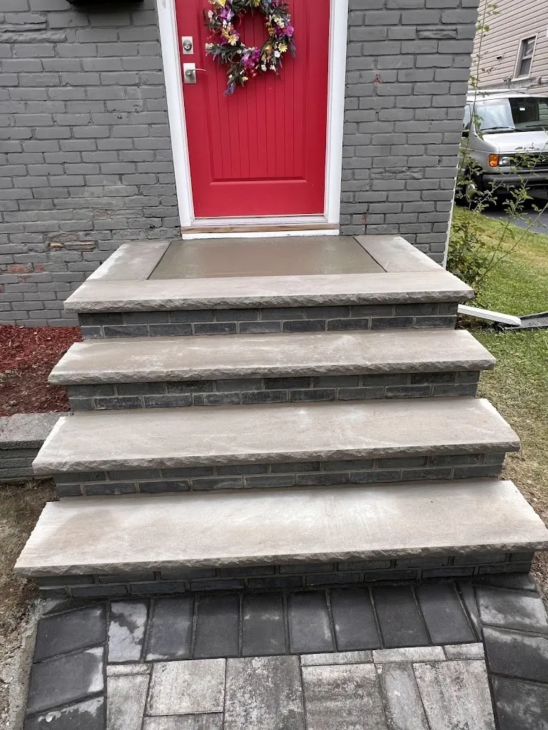 Brick steps with thick bluestone treads leading to a red front door