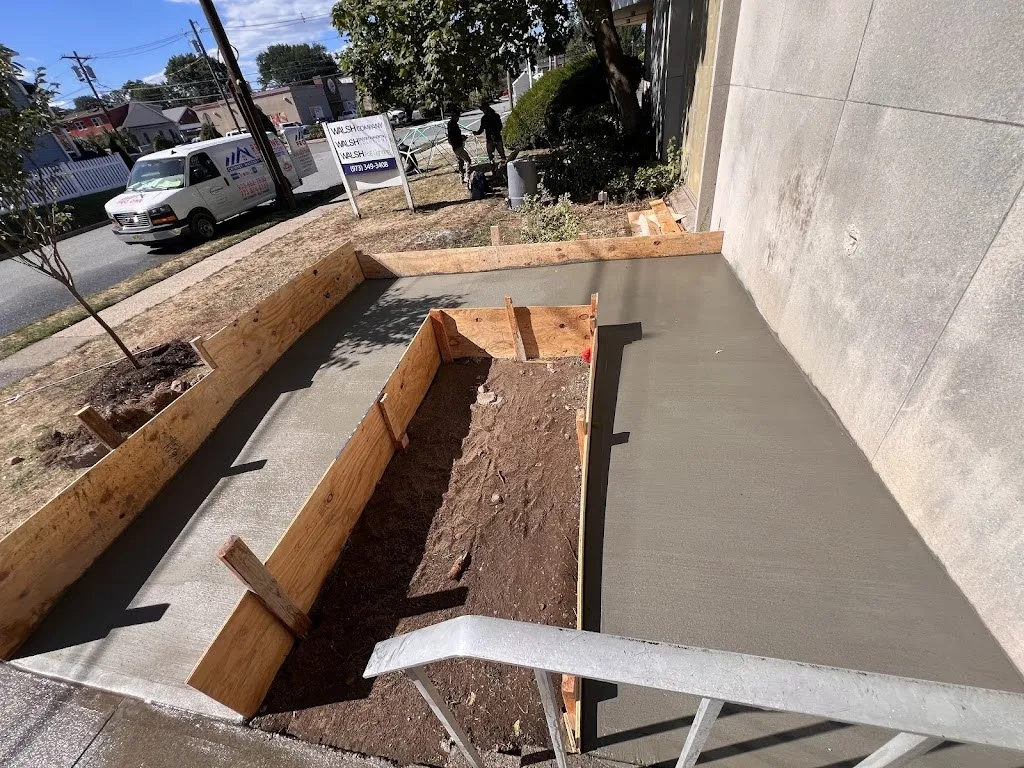 Concrete walkway forms set and partly poured at a front entrance