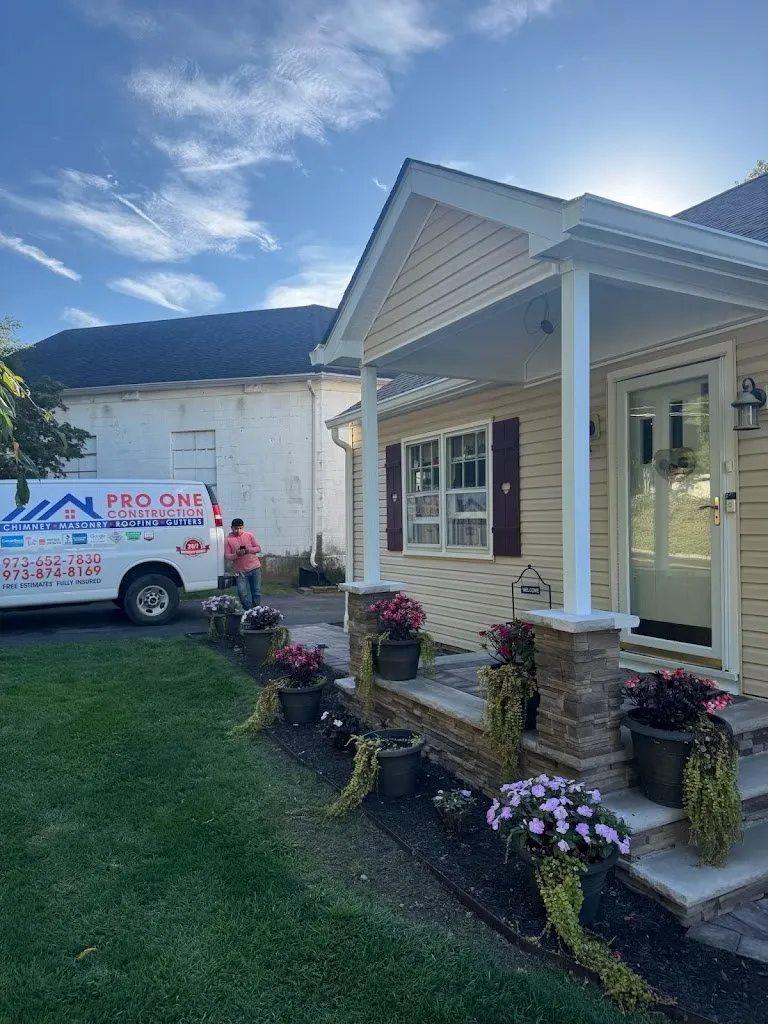 Rebuilt front porch with stone-clad columns and new landscaping