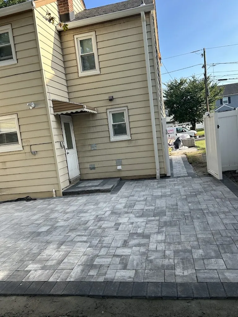 Gray paver patio with charcoal border in a narrow backyard