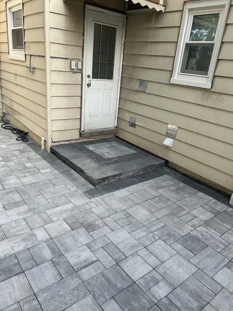Close view of gray pavers and a paver step at a back door