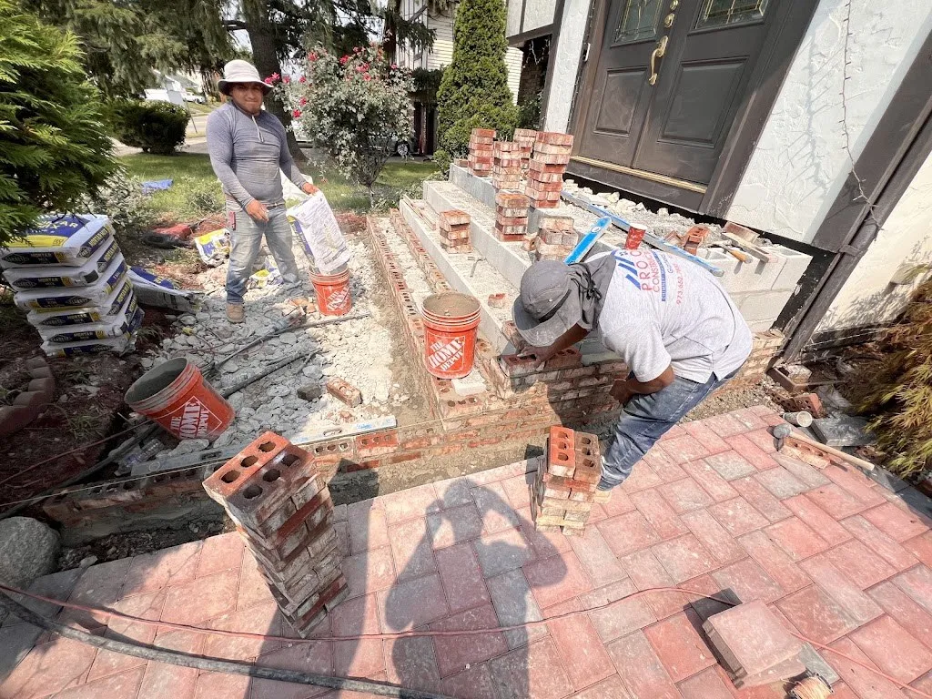 Two Pro One masons laying brick for new front steps