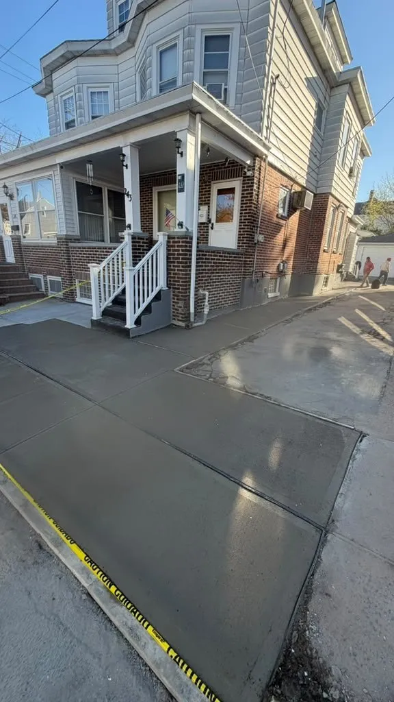New concrete driveway beside a multi-family home with a front porch