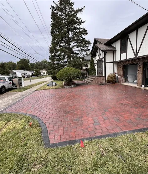 Curved red brick paver driveway with dark border