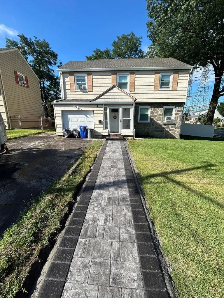 Straight paver front walkway with charcoal border leading to a colonial home