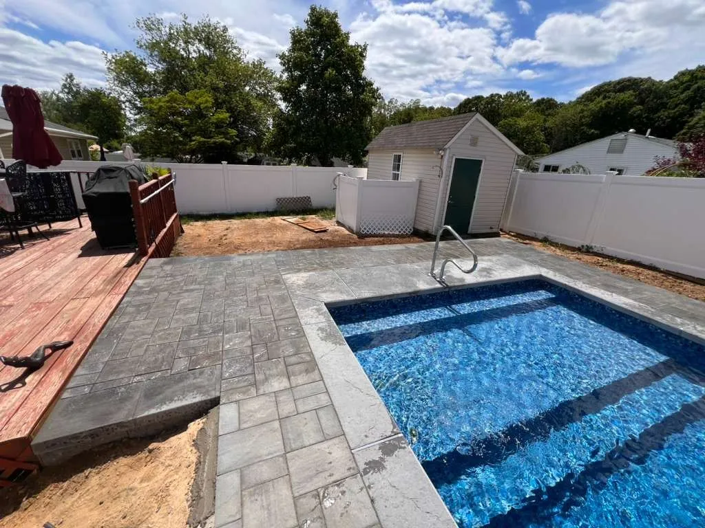 Gray paver pool deck around a rectangular in-ground pool