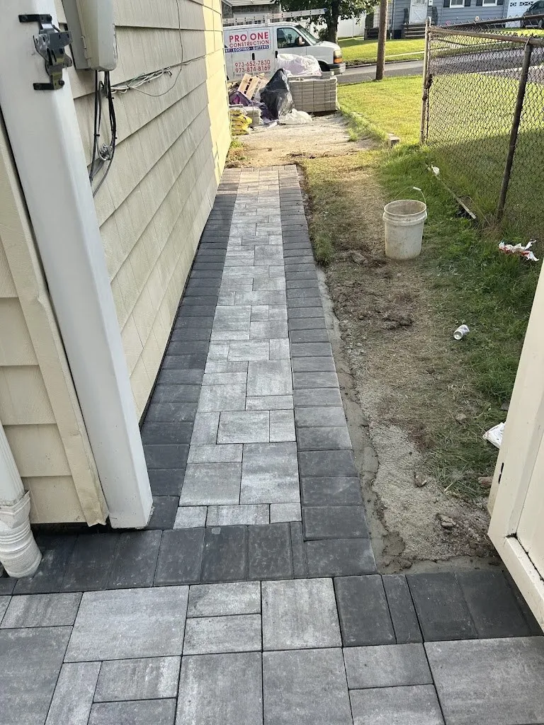 Gray paver walkway along the side of a house