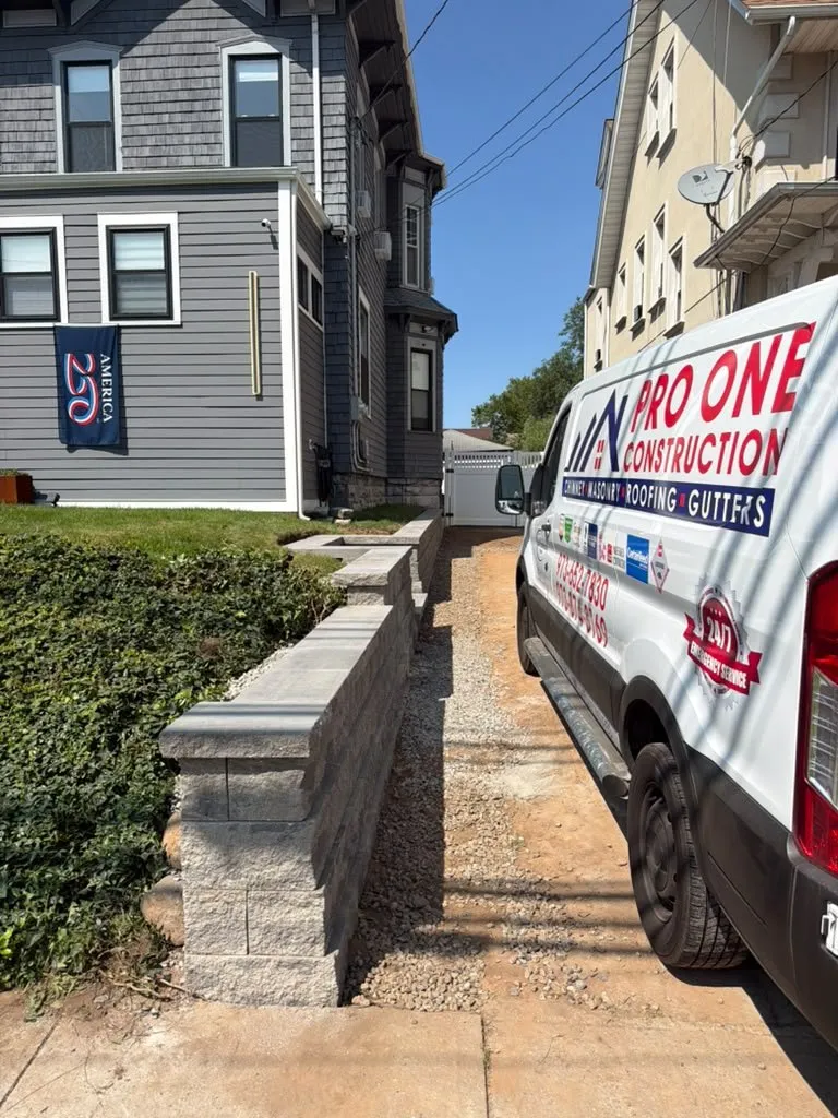 New segmental block wall along a city driveway with a Pro One van