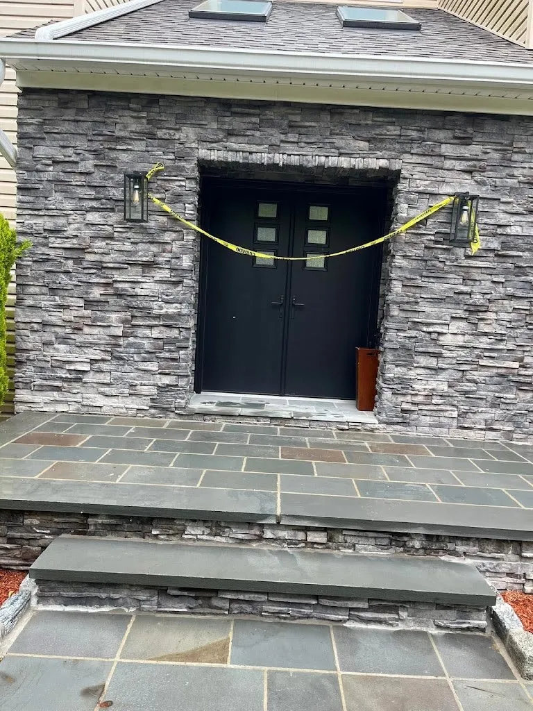 Stacked stone entry with a large bluestone landing at double doors