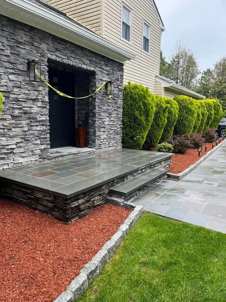 Gray stacked stone entryway with bluestone landing, steps and walkway