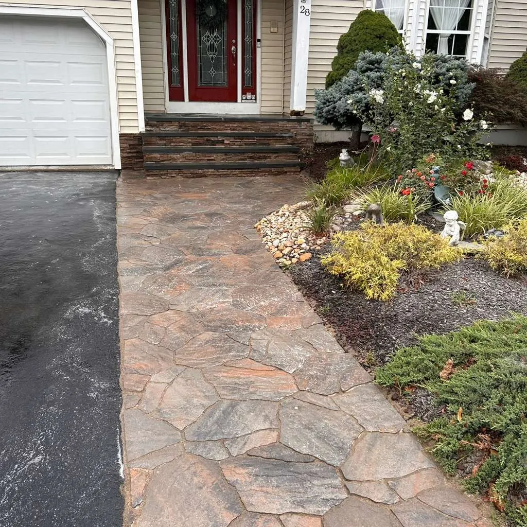 Flagstone-pattern stamped concrete walkway leading to stone veneer front steps