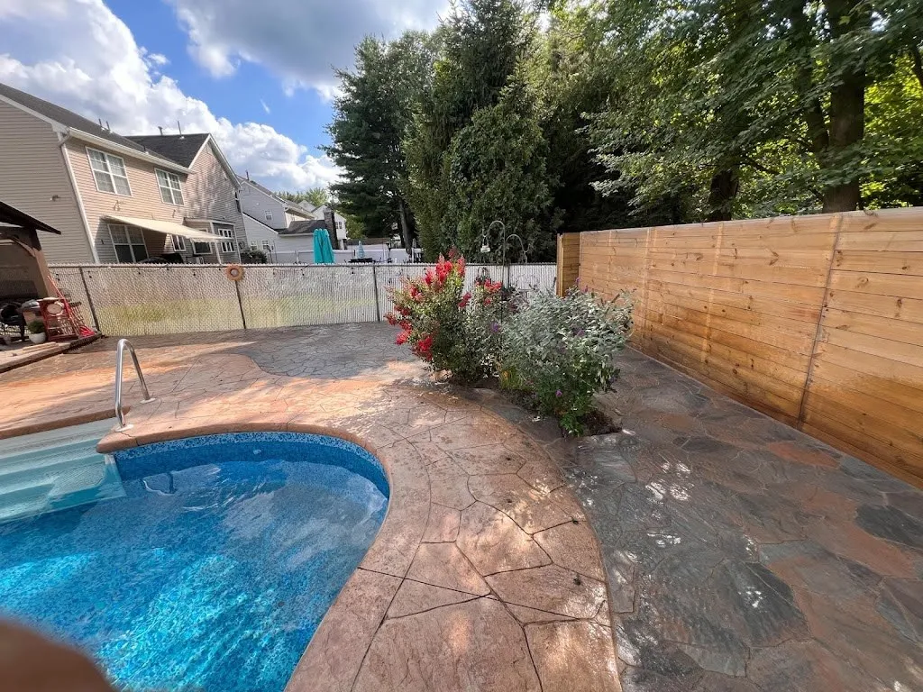 Stamped concrete pool deck around a kidney-shaped in-ground pool