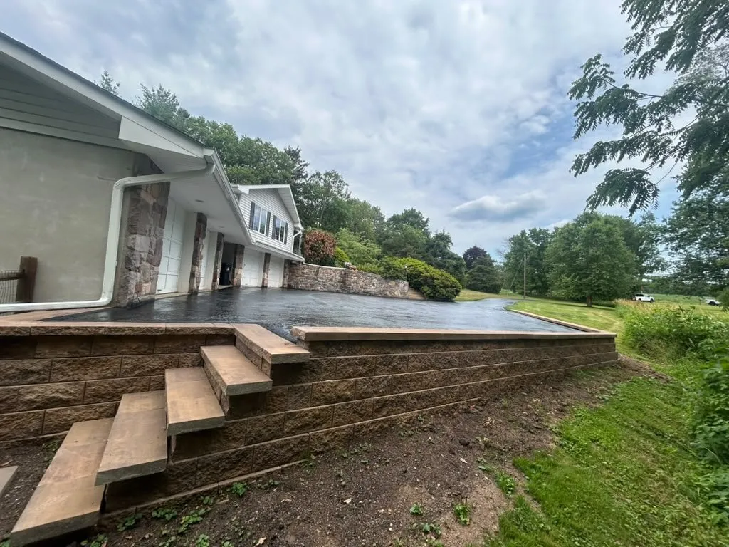 Raised stamped concrete terrace on a block retaining wall with built-in steps