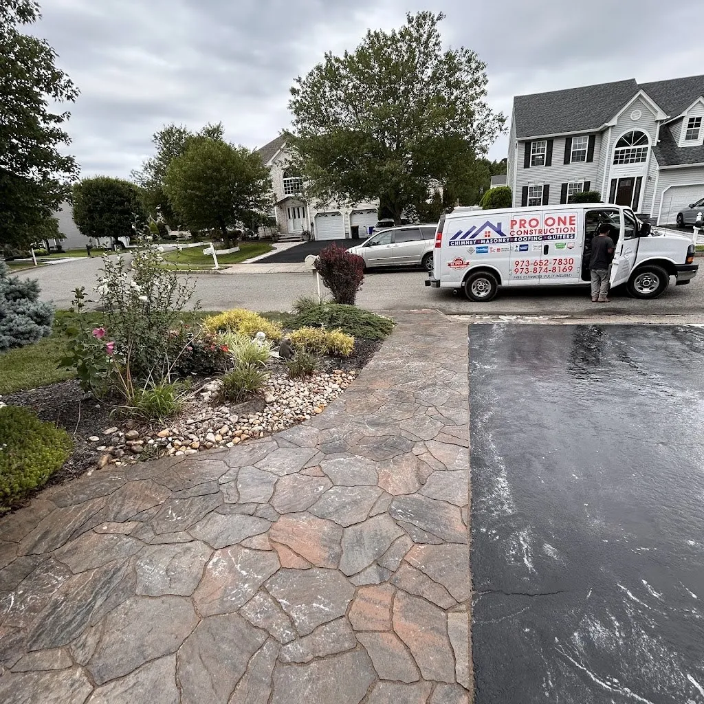 Stamped concrete walkway in a flagstone pattern beside a sealed driveway