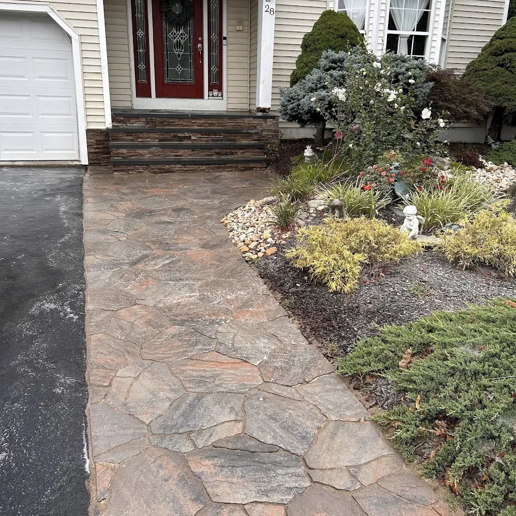 Stamped concrete walkway leading to a front entry with landscaping