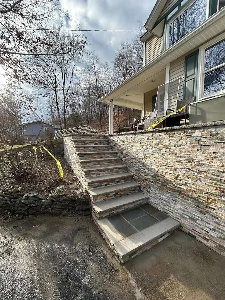 Stone steps climbing beside a stacked stone retaining wall