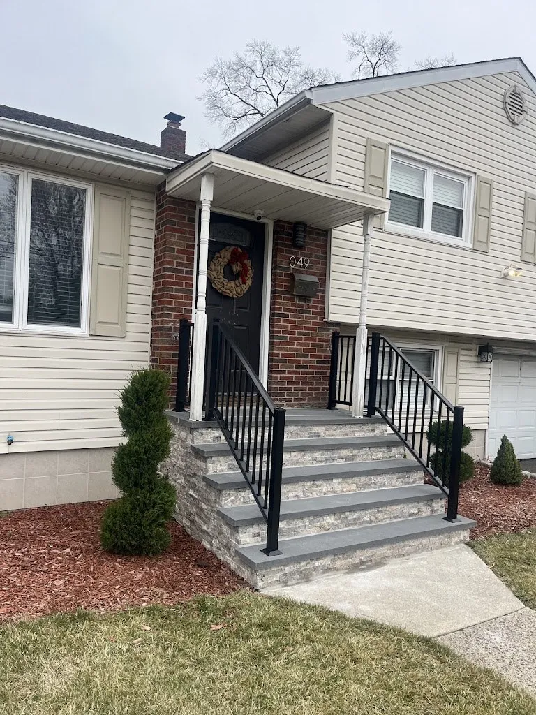 Stone veneer front steps with bluestone treads leading to a brick entry