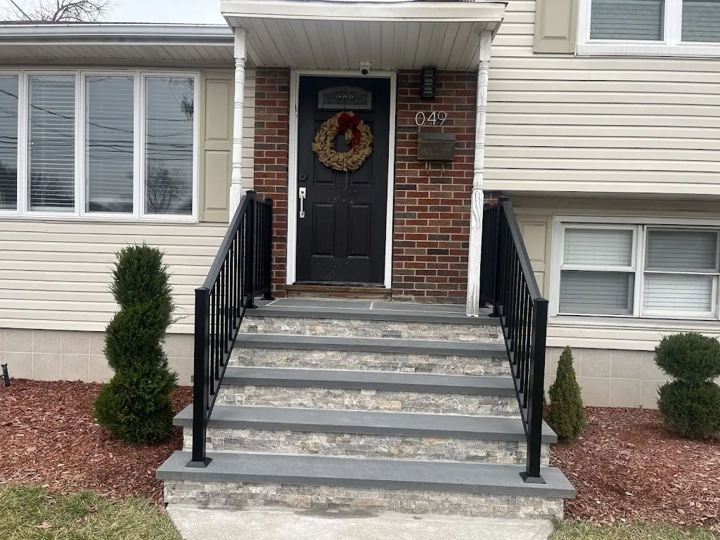 Straight-on view of stone veneer steps with bluestone treads and railings