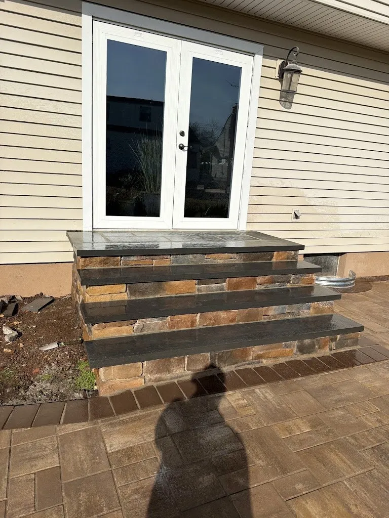 Stone veneer steps with bluestone treads outside rear French doors